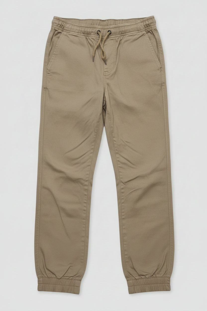 A pair of kingpin slim fit khaki chino pants with an elastic waist and drawstring, and elastic cuff ankles lay flat.