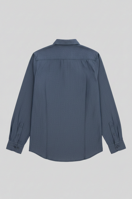 A slate blue long-sleeve button-down shirt shown from the back, featuring a subtle grid texture and a pointed collar, photographed against a neutral light gray background.