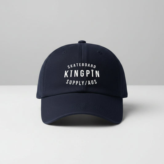 A navy blue snapback hat with 'SKATEBOARD KINGPIN SUPPLY/AUS' embroidered on the front.
