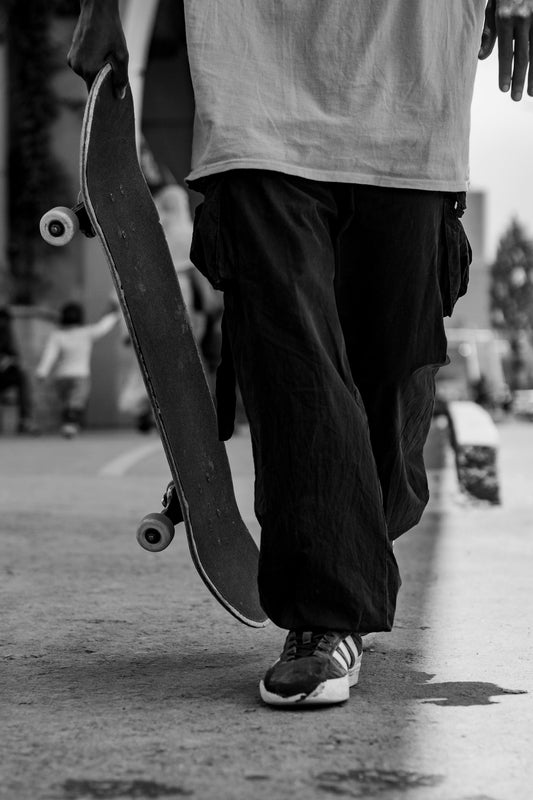A person walking with a skateboard in their hand