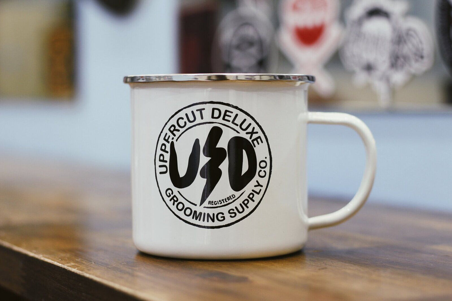 White mug with Uppercut Deluxe logo on a wooden surface