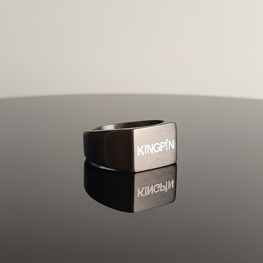 Metallic ring with 'KINGPIN' branding on a reflective surface
