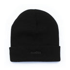 A black knit beanie hat with a folded cuff, featuring the word 'modus.' embroidered in dark gray on the front cuff, set against a plain white background.
