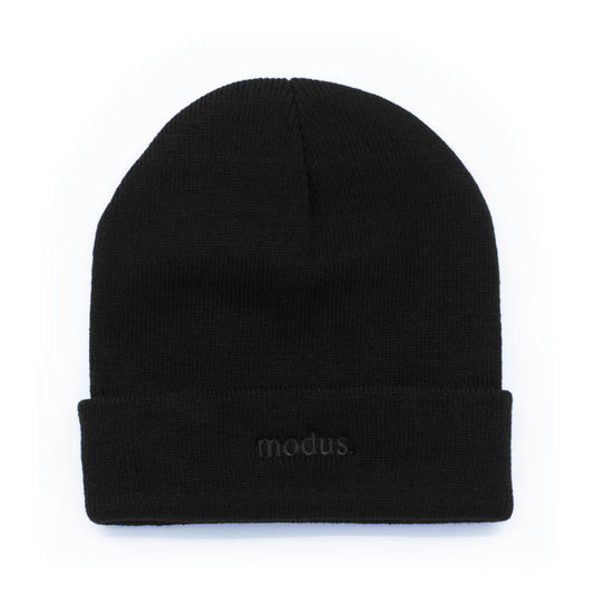 A black knit beanie hat with a folded cuff, featuring the word 'modus.' embroidered in dark gray on the front cuff, set against a plain white background.