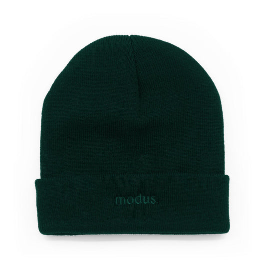 A dark forest green knit beanie with a folded cuff, featuring the word 'modus.' embroidered in matching green on the front cuff, set against a plain white background.