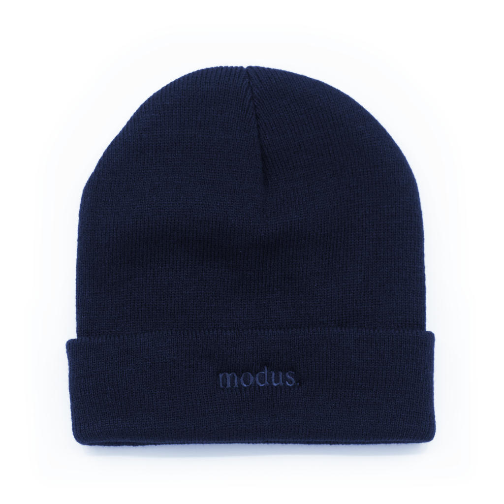A dark navy blue knit beanie hat with a folded cuff, featuring the word 'modus.' embroidered in matching navy on the front cuff, set against a plain white background.