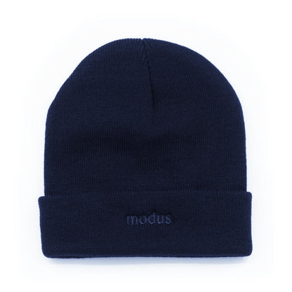 A dark navy blue knit beanie hat with a folded cuff, featuring the word 'modus.' embroidered in matching navy on the front cuff, set against a plain white background.