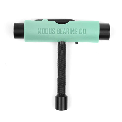 T-shaped tool with green top and black handle on a white background