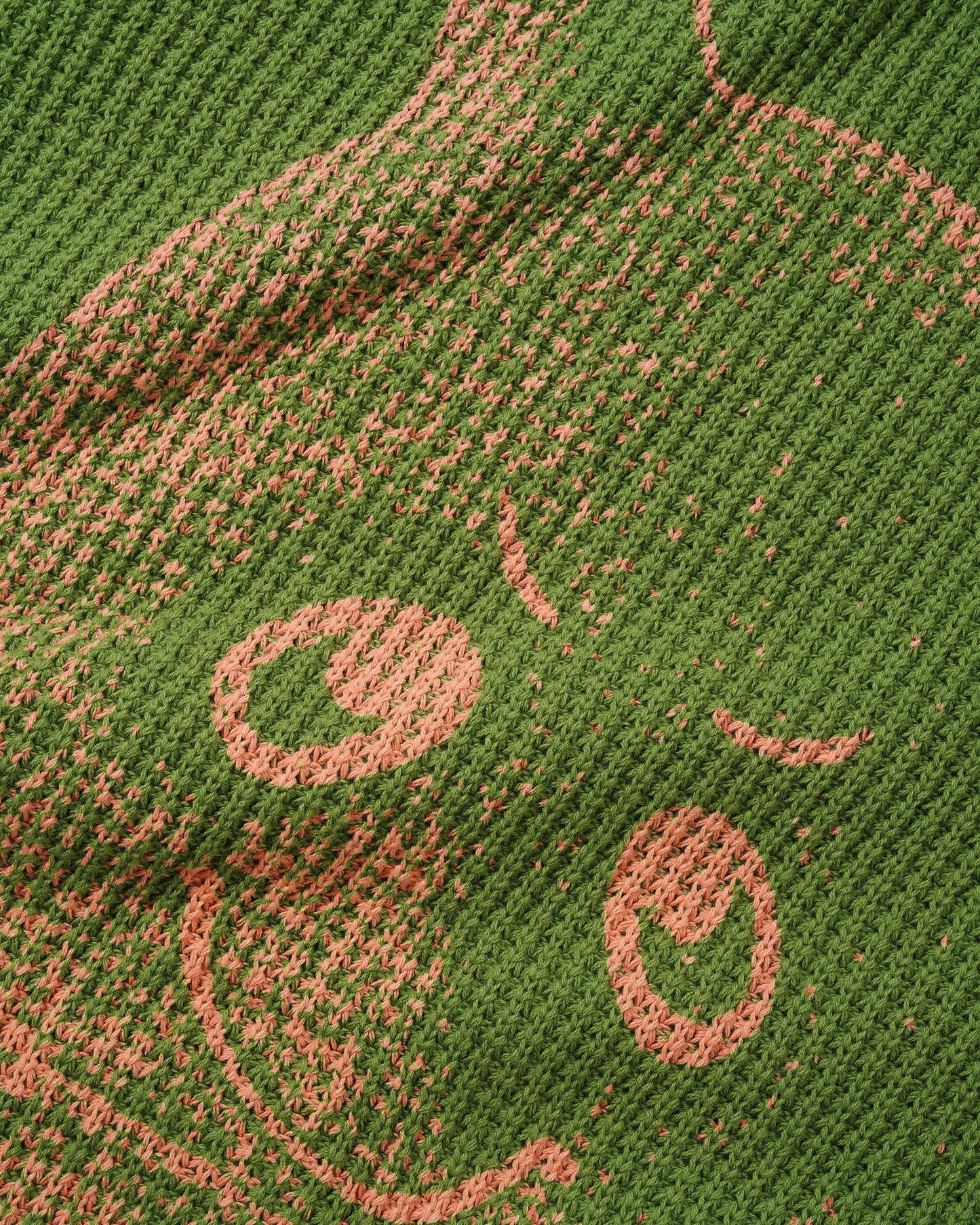 Close-up of a textured green surface with pink patterns