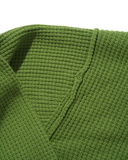 Close-up of a green knitted sweater with a V-neck