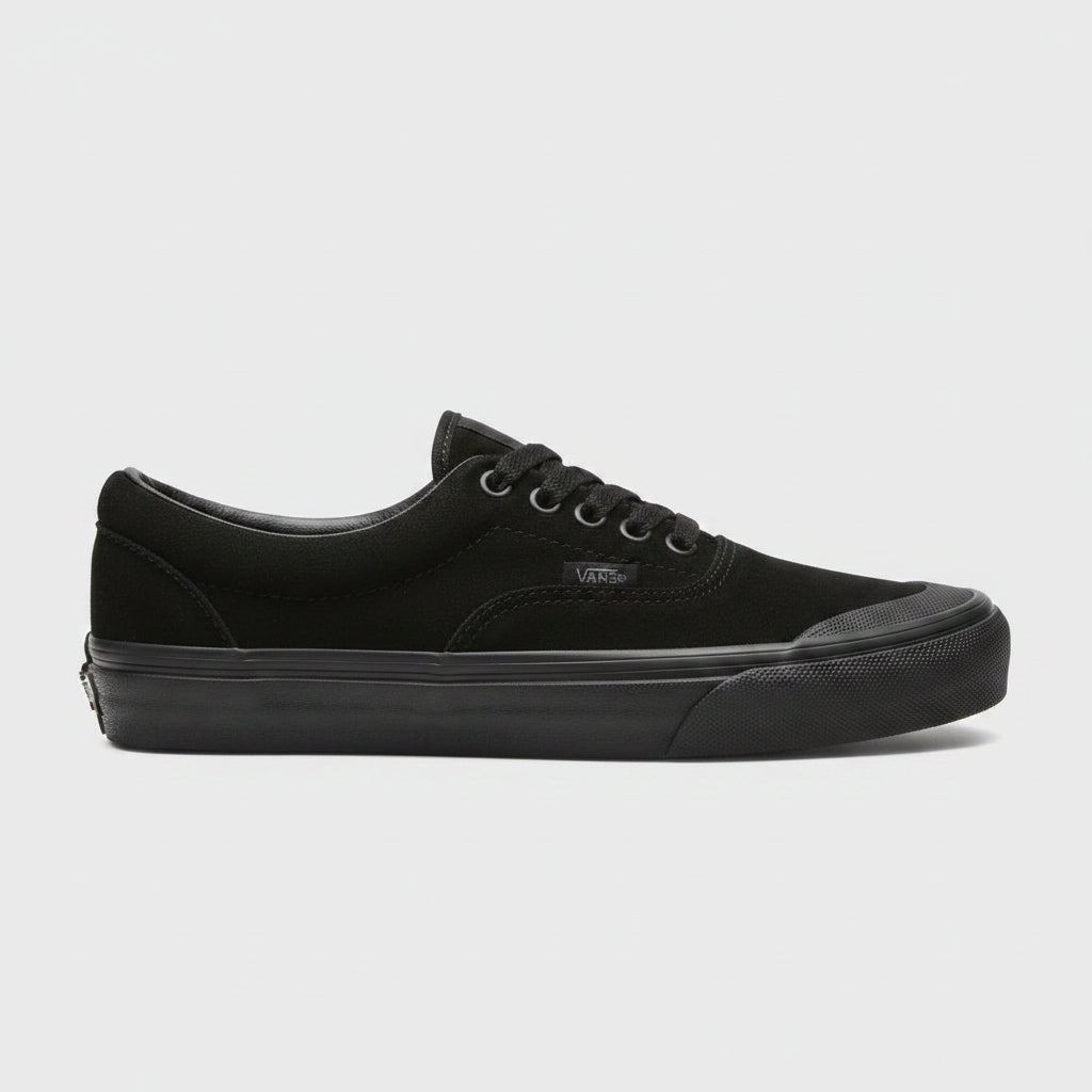 A black Vans era sneaker with a thick black sole, shown from the side against a light concrete floor.