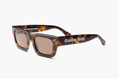Tortoiseshell sunglasses with brown lenses and the text 'Cramling Death' printed in white on the side of the right temple, shown on a light gray background.