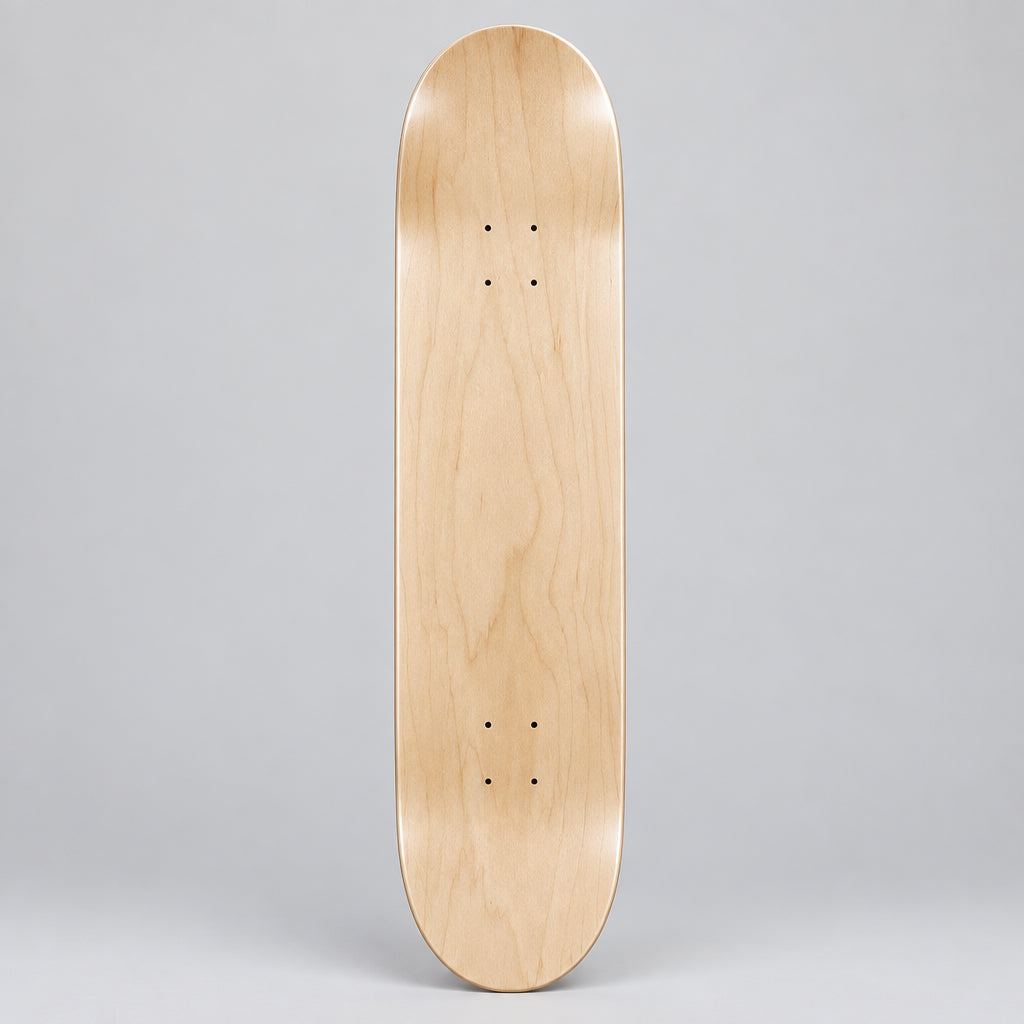 A natural unfinished wood skateboard deck with visible grain, resting flat on a light brown wood plank floor.