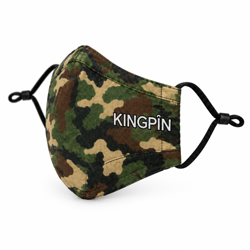 A fabric face mask with a green, brown, and beige camouflage pattern, featuring the brand name 'KINGPIN' embroidered in white with a black outline on the side. It has black elastic ear loops and is shown on a clean white background.