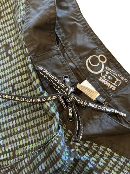 Close-up of a Juicy Clothing shorts garment showing the inner waistband, black drawstring with white logo text, and a green, gray, and black houndstooth pattern.
