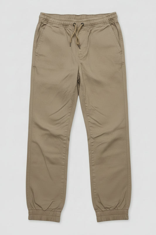 A pair of kingpin slim fit khaki chino pants with an elastic waist and drawstring, and elastic cuff ankles lay flat.