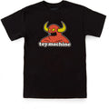 A toy machine monster black short-sleeve crewneck t-shirt featuring a graphic of a red horned monster with yellow horns and the text 'toy machine' printed below it, displayed flat against a white background.