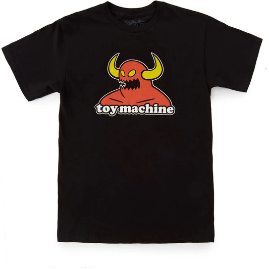 A toy machine monster black short-sleeve crewneck t-shirt featuring a graphic of a red horned monster with yellow horns and the text 'toy machine' printed below it, displayed flat against a white background.